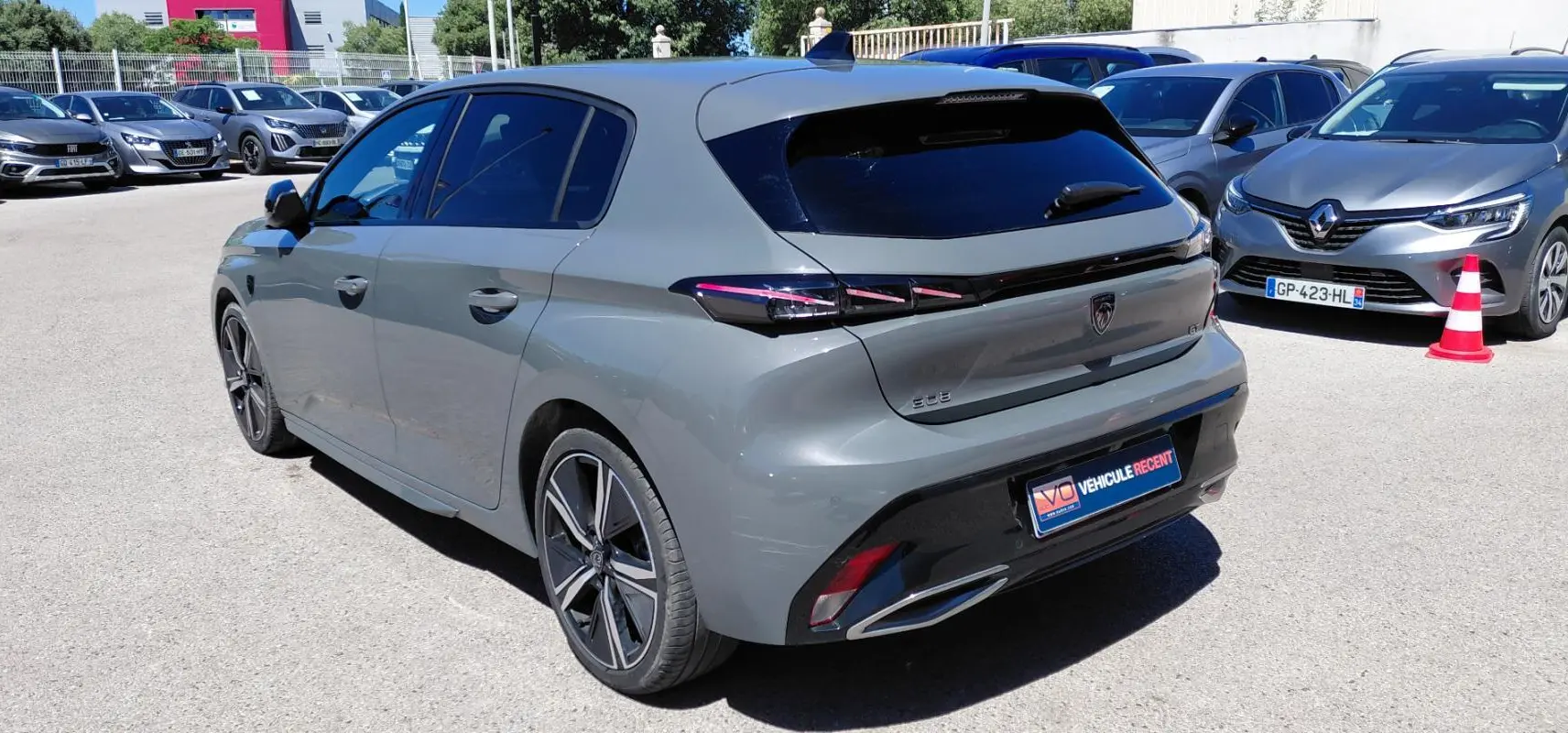 Vue 3/4 arrière droite d’une Peugeot 308 Hybrid 145 gris avec jantes alliage 18 pouces et feux arrière LED.
