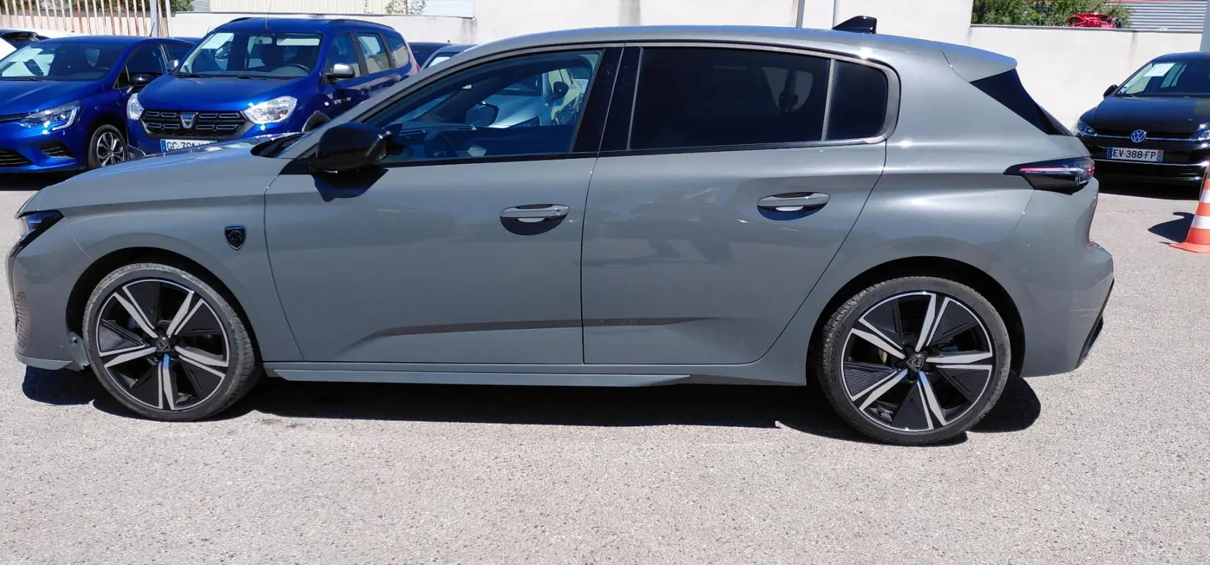Vue de profil côté gauche d'une Peugeot 308 Hybrid 145 e-DCS6 GT gris avec jantes alliage 18 pouces.