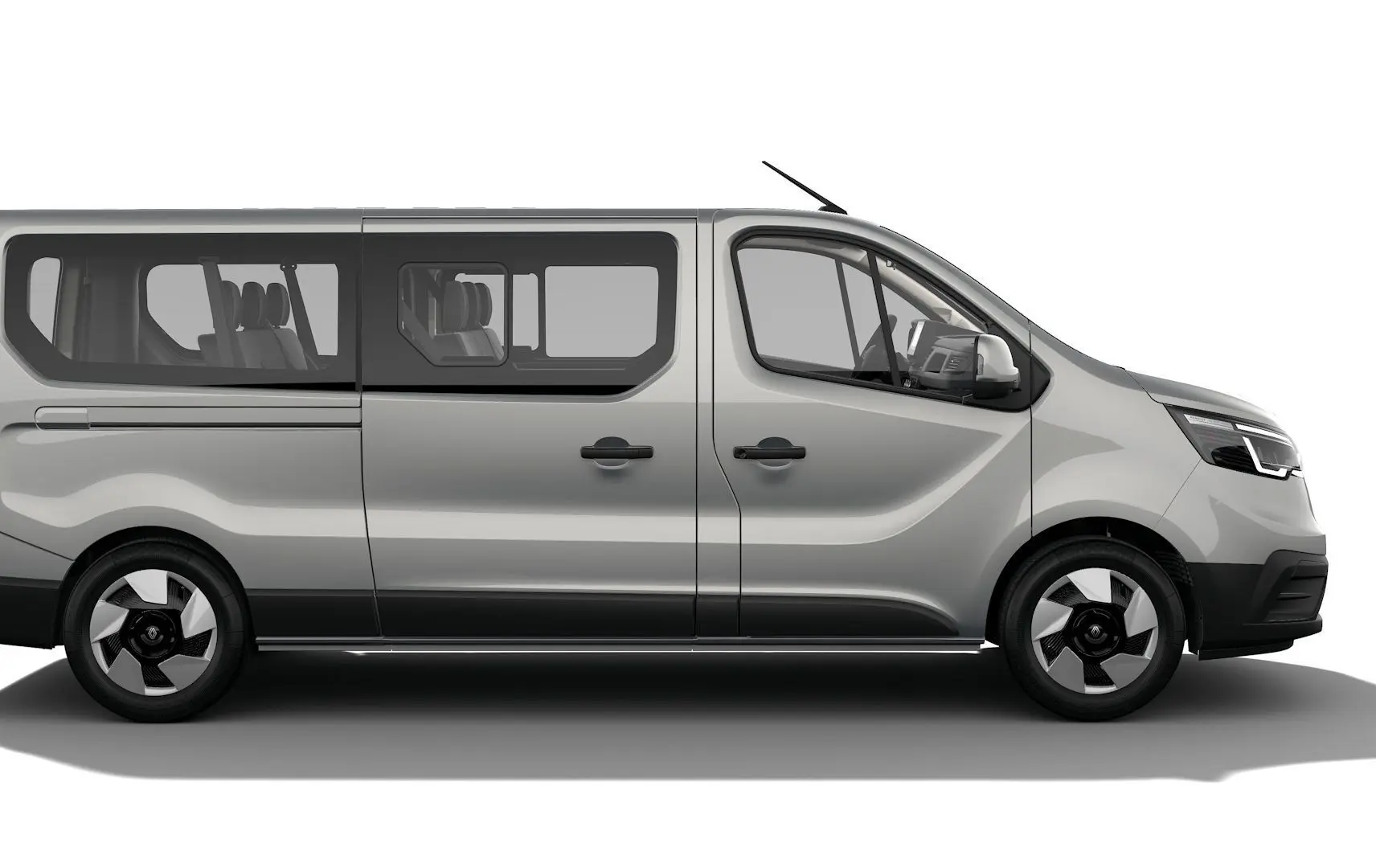 Profil droit du Renault Trafic Combi gris Highland 2026 avec grandes fenêtres et jantes modernes noires et argentées.