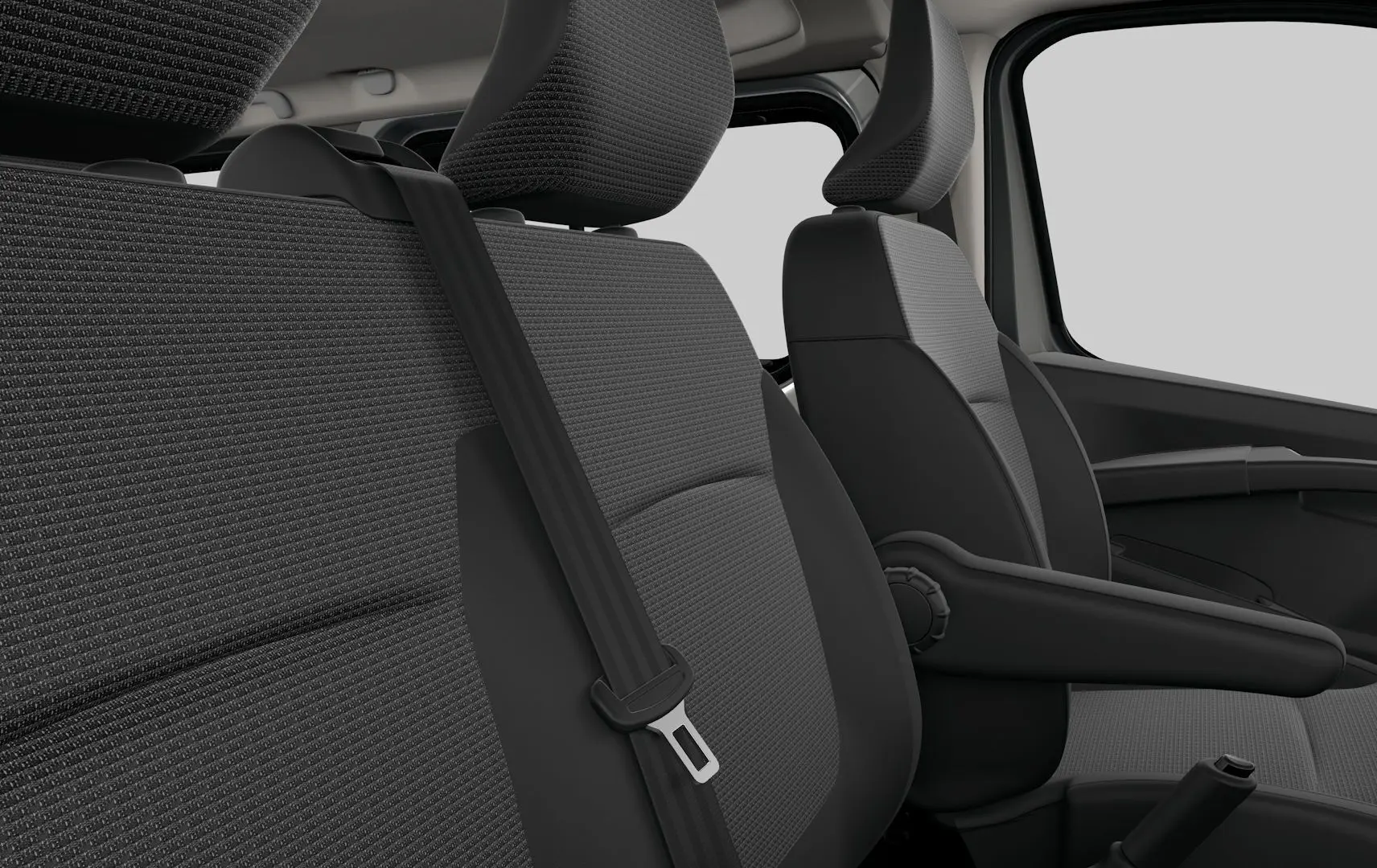 Gros plan sur les sièges avant gris tissu du Renault Trafic Combi 2026, avec ceinture de sécurité et accoudoir côté droit.