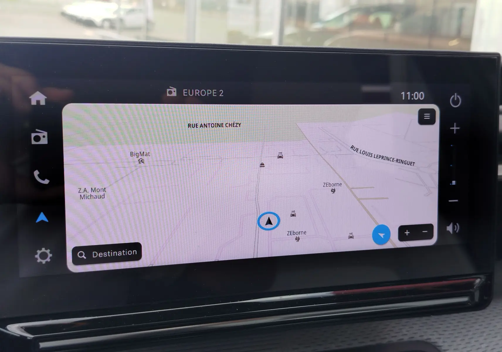 Écran tactile du système de navigation de la Citroën C3 2025, affichant une carte avec options de zoom et menu latéral.