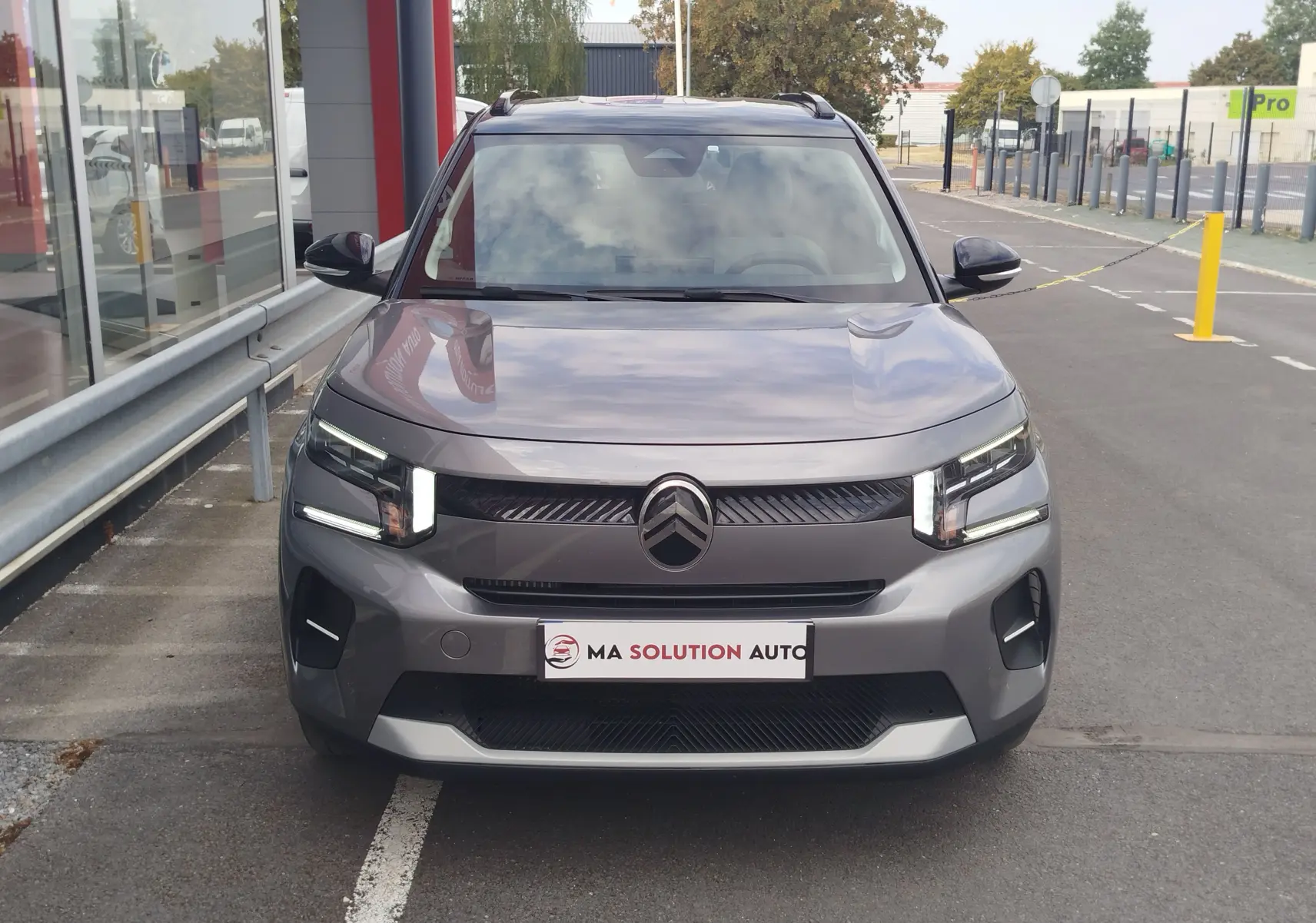 Vue avant d'une Citroën C3 2025 gris foncé avec toit noir, phares LED et calandre distinctive.