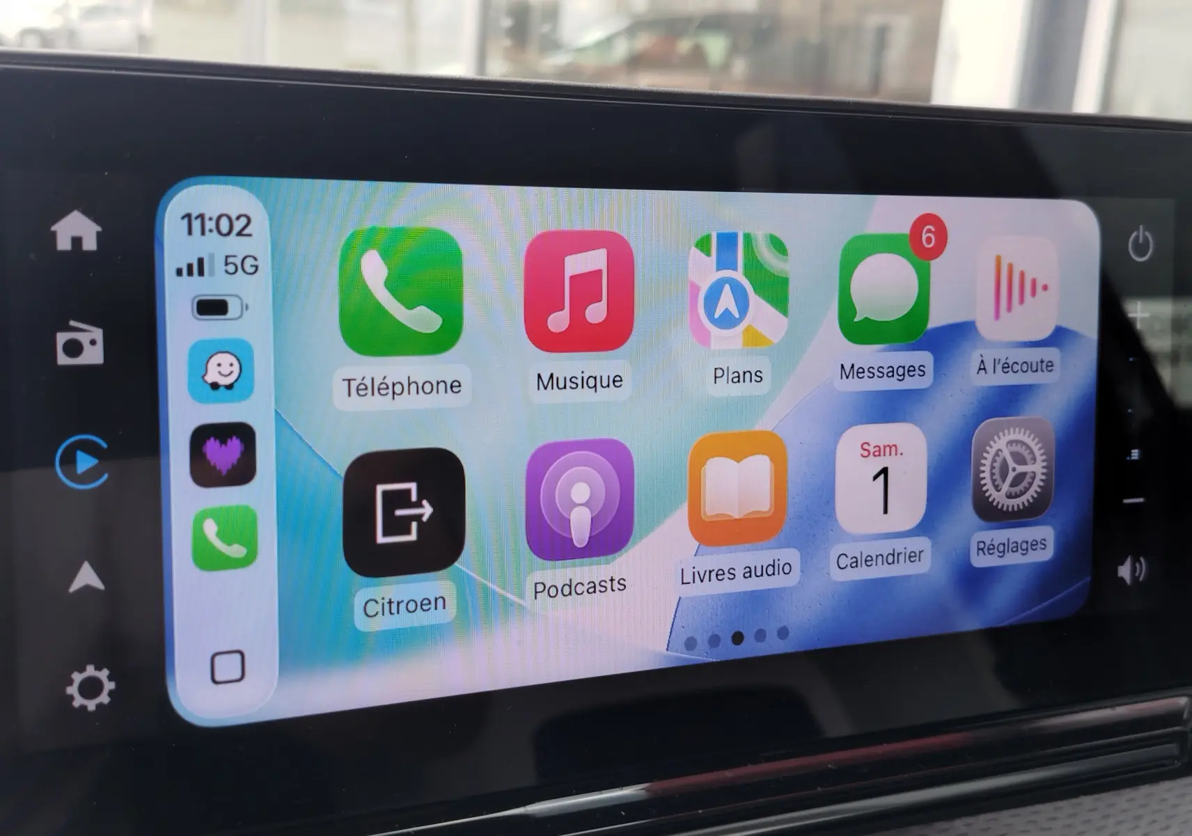Écran tactile intérieur de la Citroën C3 2025 affichant l’interface Apple CarPlay avec plusieurs applications colorées.