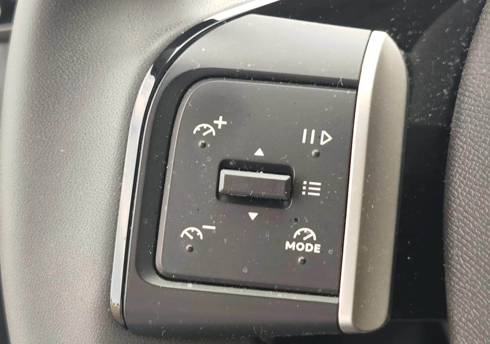 Gros plan sur les commandes de régulateur de vitesse de la Citroën C3 2025, finition gris foncé avec toit noir.