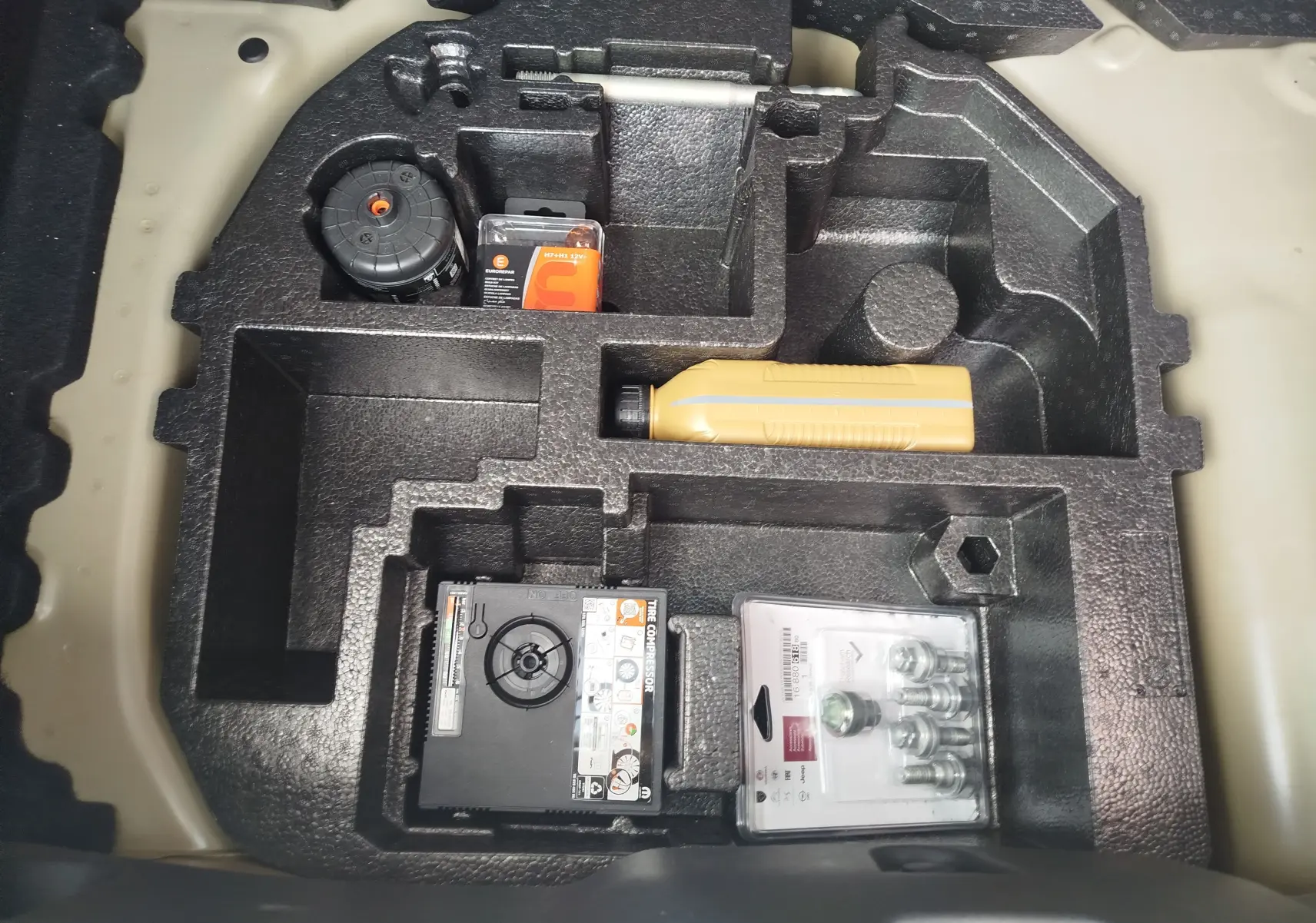 Rangement sous coffre de la Citroën C3 2025, compartiments en mousse noire avec kit de réparation pneus et accessoires.