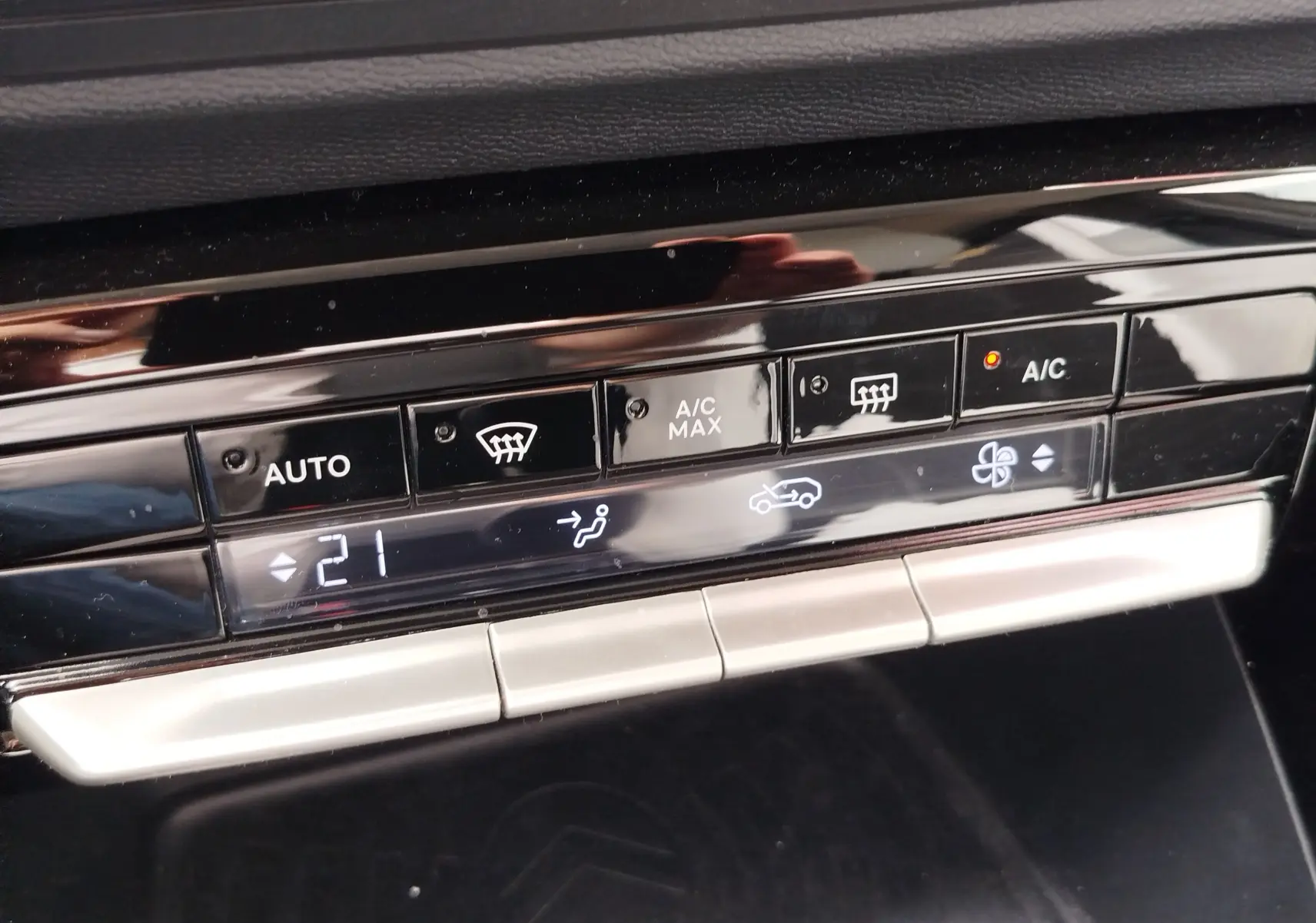 Détail du tableau de bord de la Citroën C3 2025, montrant les commandes de climatisation automatique à 21°C.