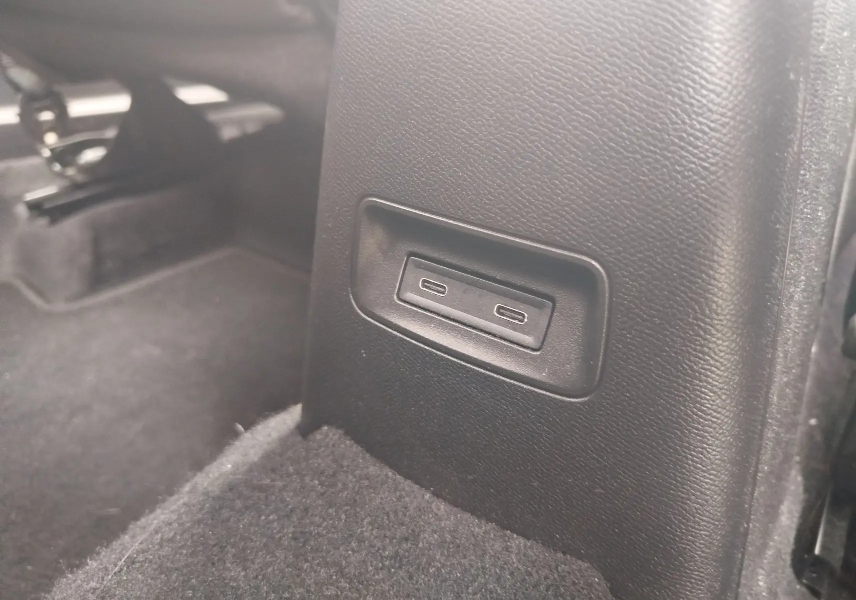 Gros plan sur les ports USB-C situés à l'arrière de la console centrale d'une Citroën C3 2025 gris foncé.