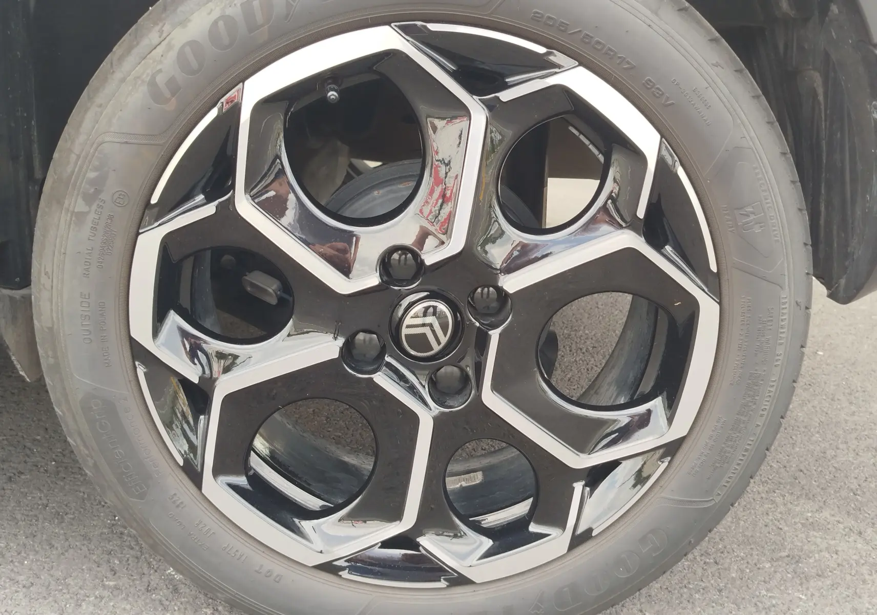 Gros plan sur la jante noire et argentée au design hexagonal d'une Citroën C3 2025 gris foncé toit noir.