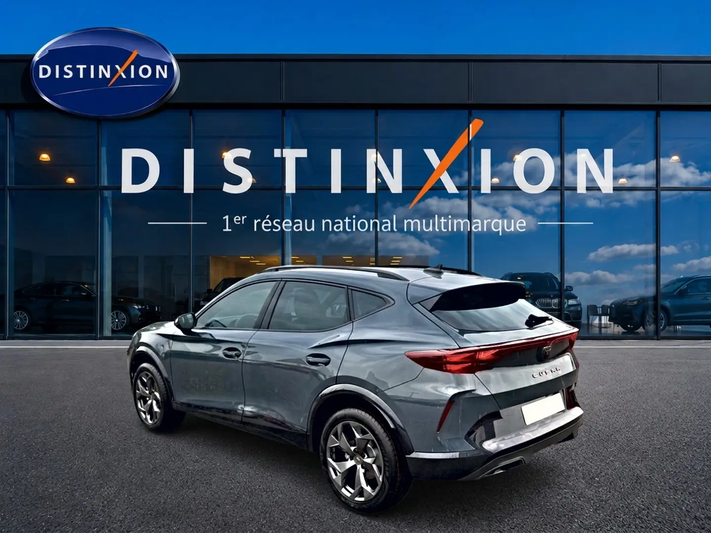 Vue 3/4 arrière droite d’un CUPRA Formentor bleu fjord 2026 avec feux arrière LED et jantes 18 pouces devant un showroom Distinxion.