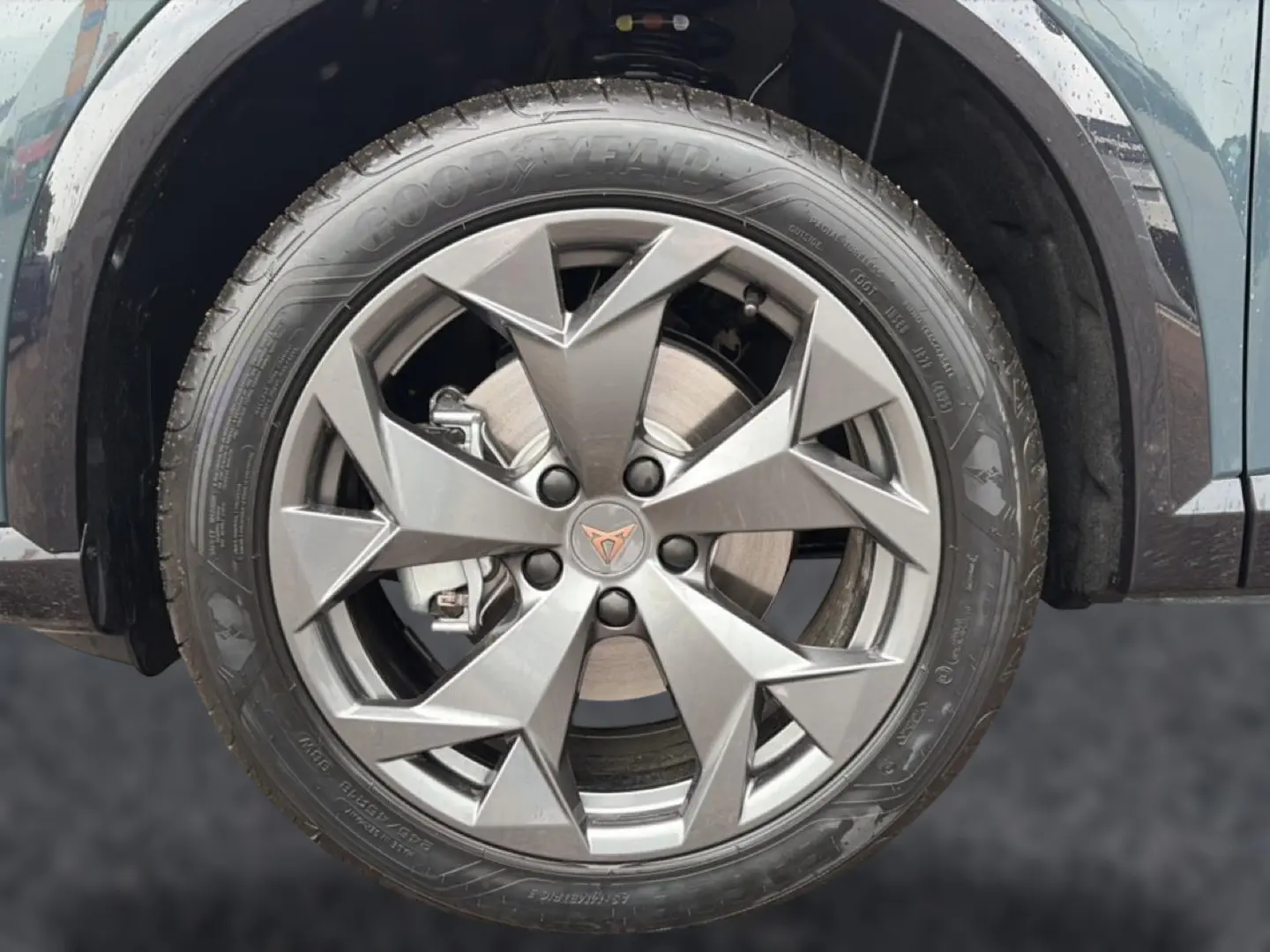 Gros plan sur la jante en alliage gris avec logo CUPRA d’un CUPRA Formentor bleu fjord, roue avant droite visible.