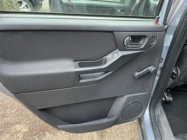 Vue intérieure de la porte arrière droite grise d'une Opel Meriva A 2010 avec poignée manuelle et haut-parleur intégré.