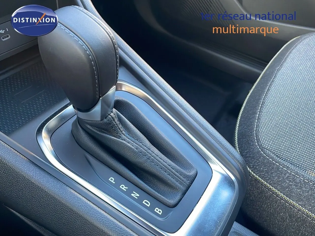 Le levier de vitesses automatique en cuir noir du Renault Captur E-Tech Hybrid 2025, avec sellerie grise visible.