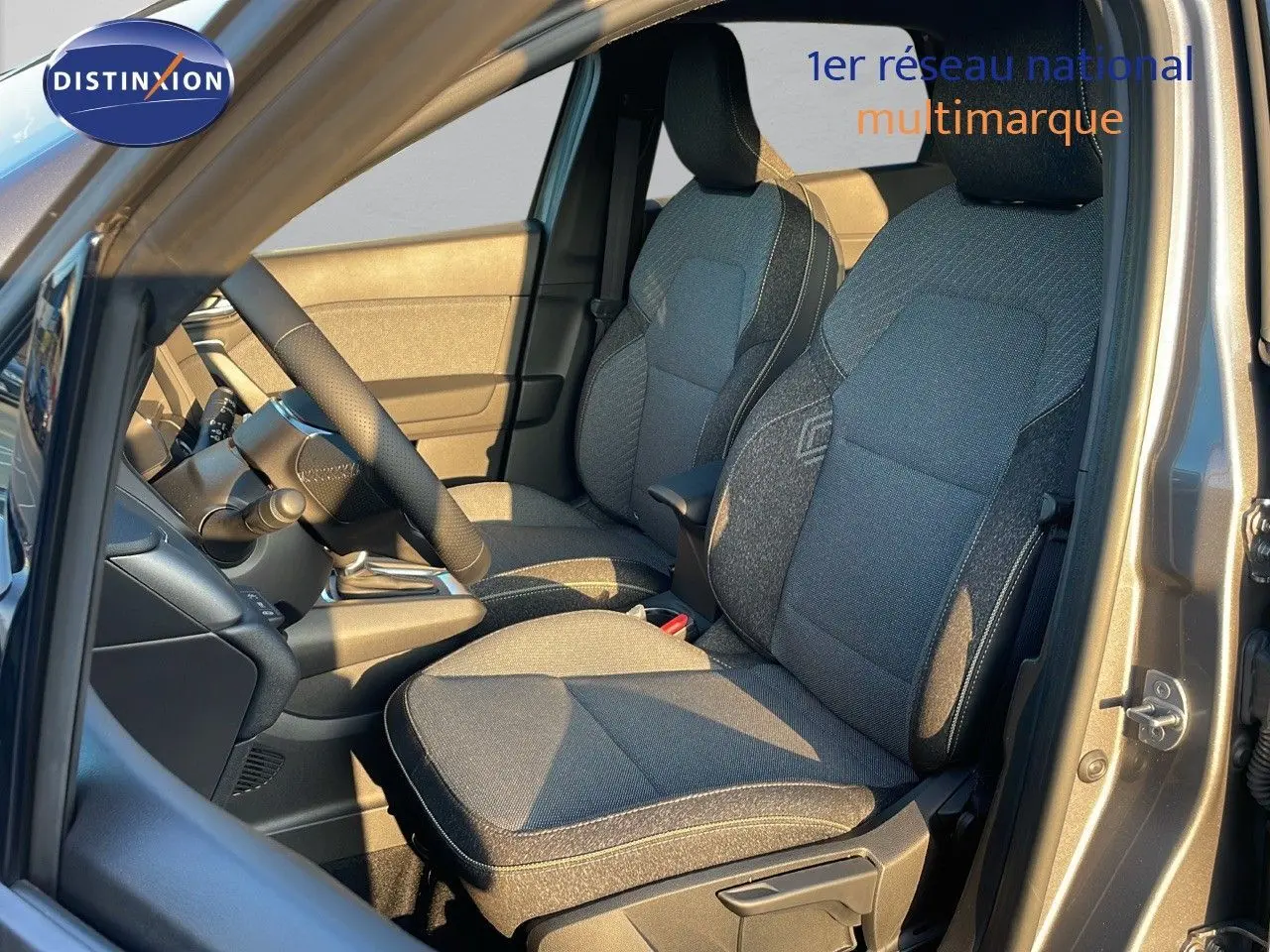 Vue intérieure côté conducteur du Renault Captur gris Cassiopée Métal 2025, sièges en tissu noir et gris.