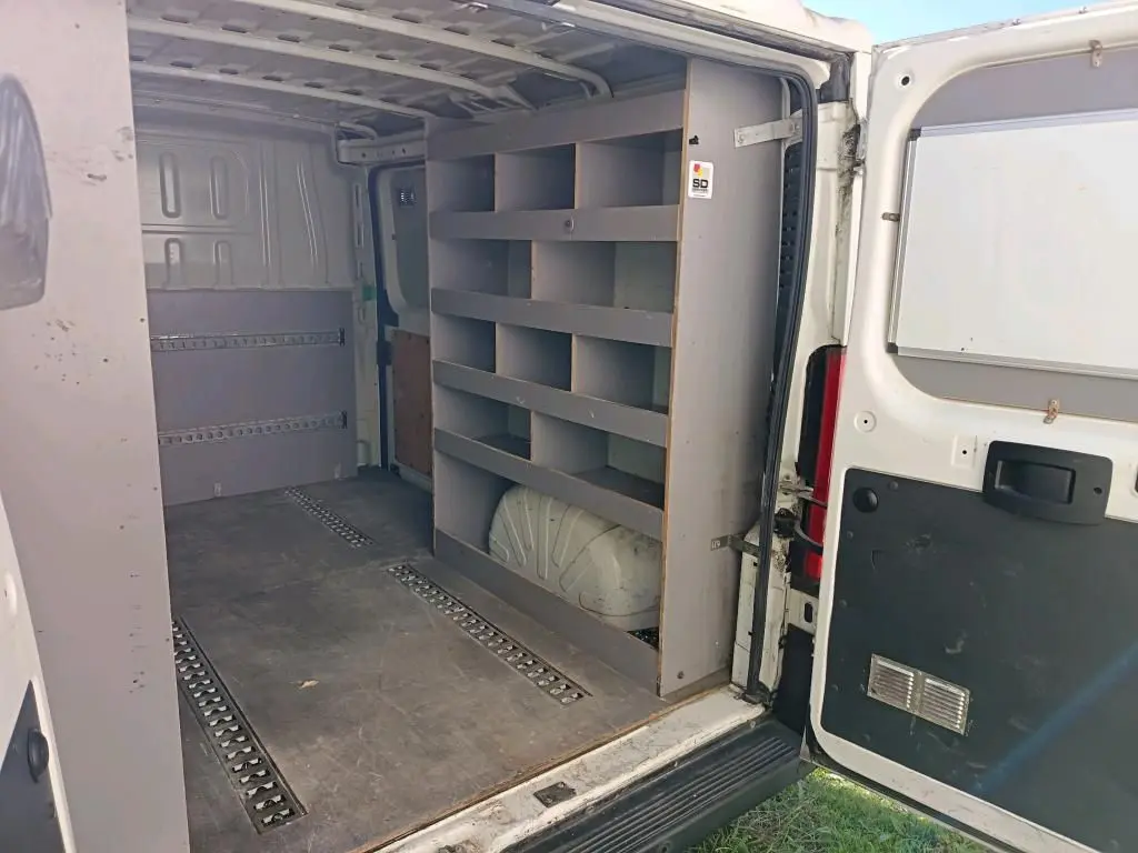 Vue intérieure arrière du Citroën Jumper blanc 2020 avec étagères de rangement et porte ouverte côté droit.