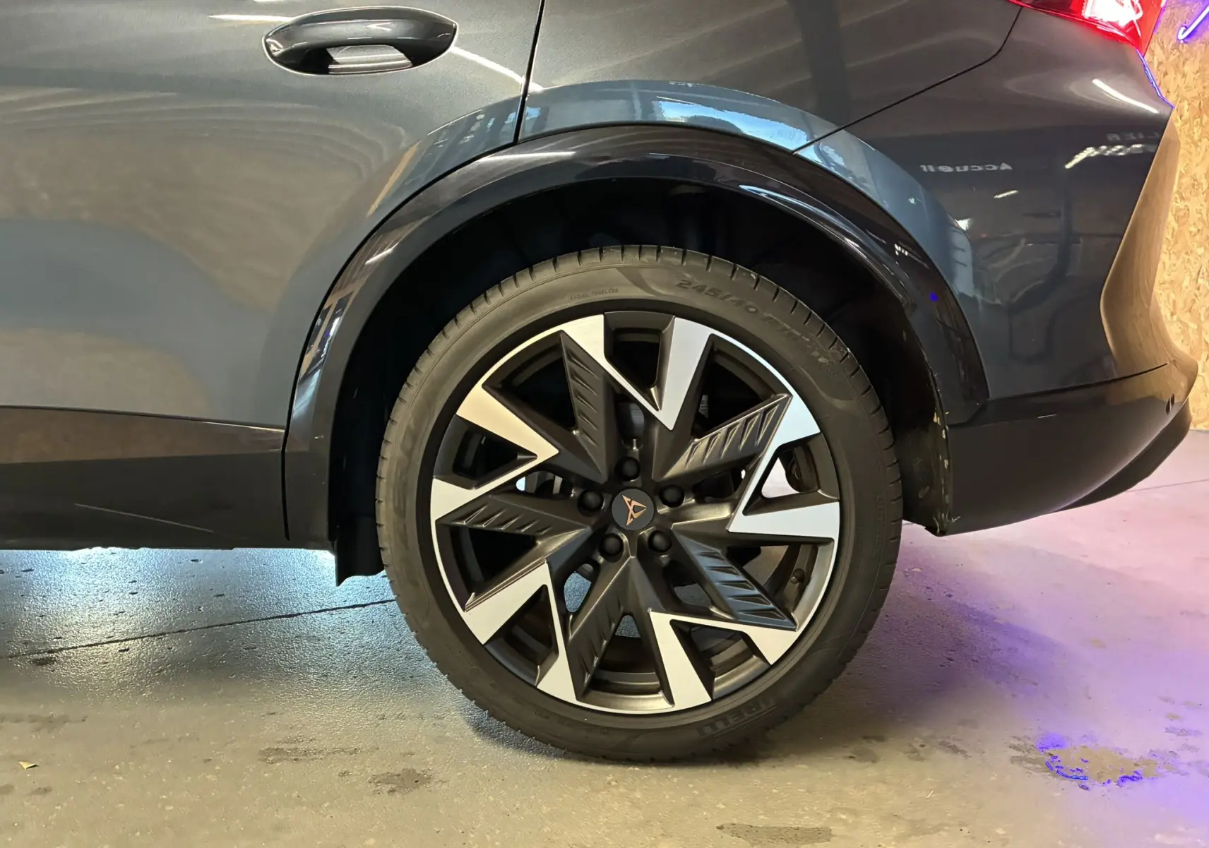 Gros plan sur la roue arrière droite du CUPRA Formentor gris foncé 2024, mettant en valeur la jante bi-ton au design dynamique.