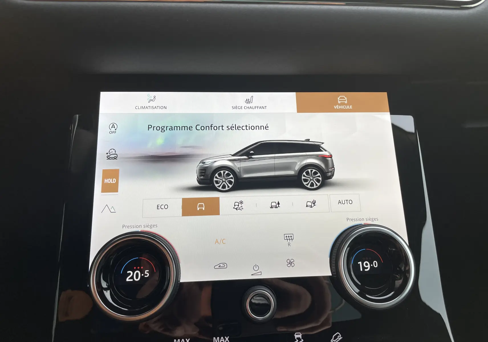 Gros plan sur la console centrale noire du Range Rover Evoque 200D SE R-Dynamic avec levier de vitesse automatique et sellerie cuir noir.