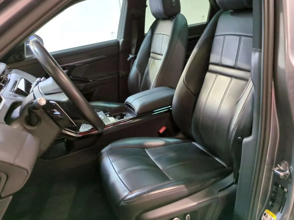 Vue arrière d'un Range Rover Evoque 200D SE R-Dynamic gris Eiger avec feux LED allumés, stationné devant un showroom.