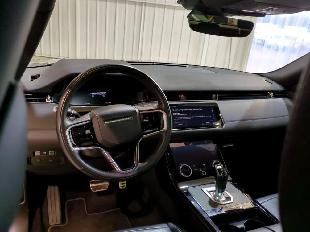 Vue intérieure côté conducteur du Range Rover Evoque 200D SE R-Dynamic 2021 avec sièges cuir noir et toit panoramique.