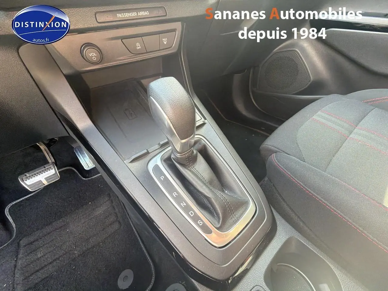 Gros plan sur la console centrale et levier de vitesse automatique du Ford Puma bleu avec surpiqûres rouges sur siège tissu.