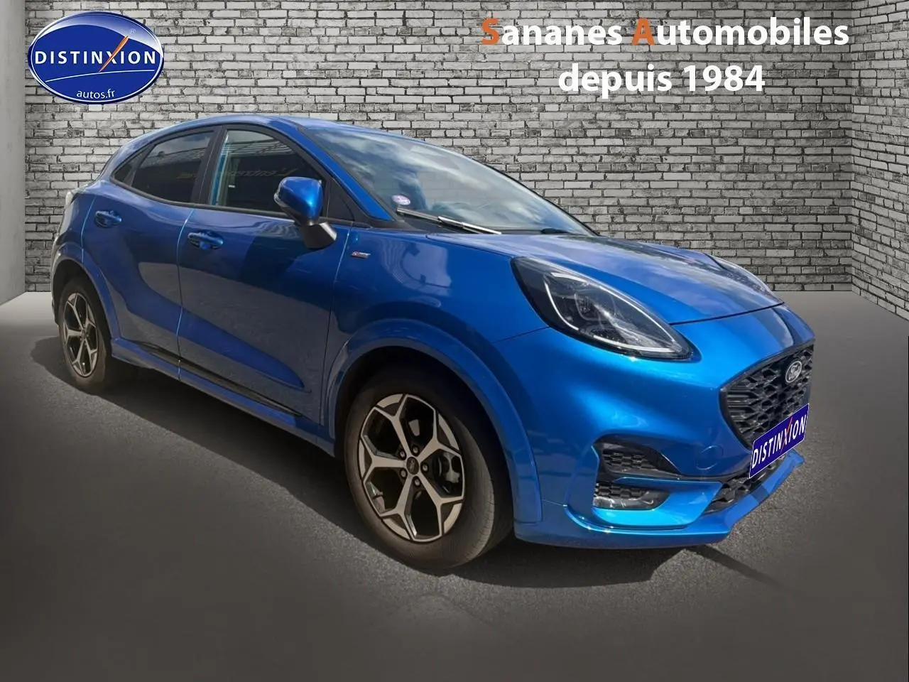 Ford Puma bleu 3/4 avant droit avec jantes alliage 17 pouces et kit carrosserie ST-Line visible.