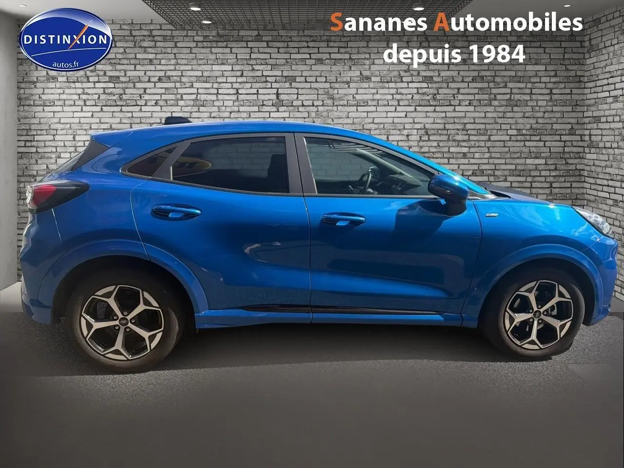 Vue de profil côté gauche d'un Ford Puma bleu métallisé avec jantes alliage 17 pouces et vitres arrière surteintées.