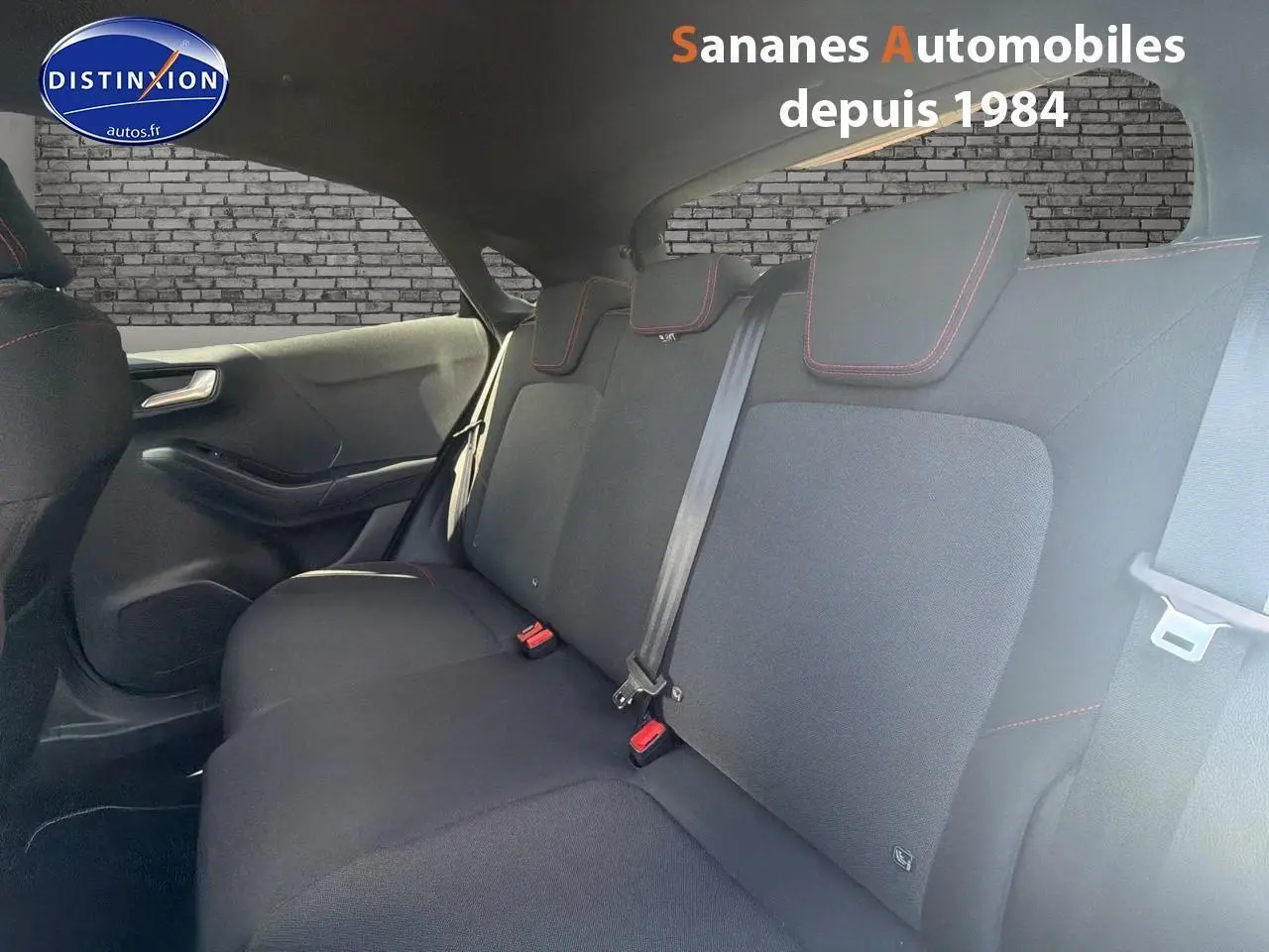 Banquette arrière en tissu noir avec surpiqûres rouges dans un Ford Puma 2025, vue côté droit intérieur.