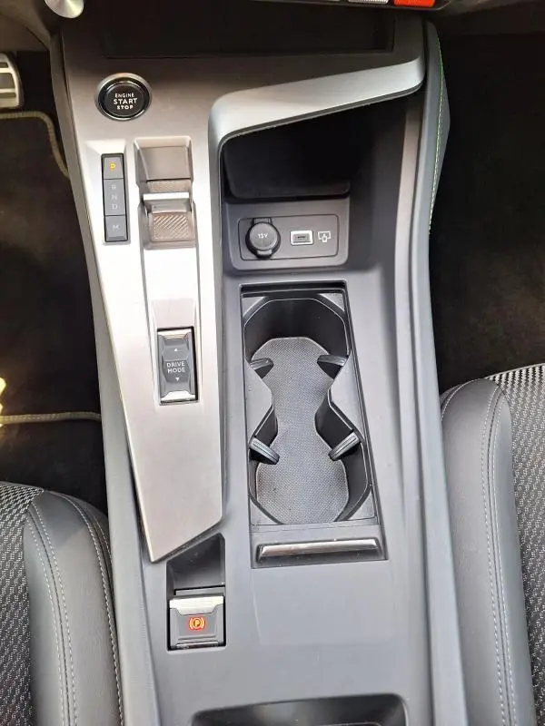 Vue plongeante sur la console centrale de la Peugeot 308 Hybrid 145 e-DCS6 GT 2025, avec bouton start, levier de vitesses et prises USB.
