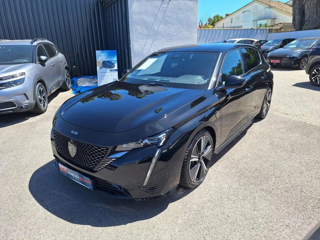 PEUGEOT 308 Hybrid 145 e-DCS6 GT noir en 3/4 avant droit, jantes alliage 18 pouces et feux LED distinctifs.