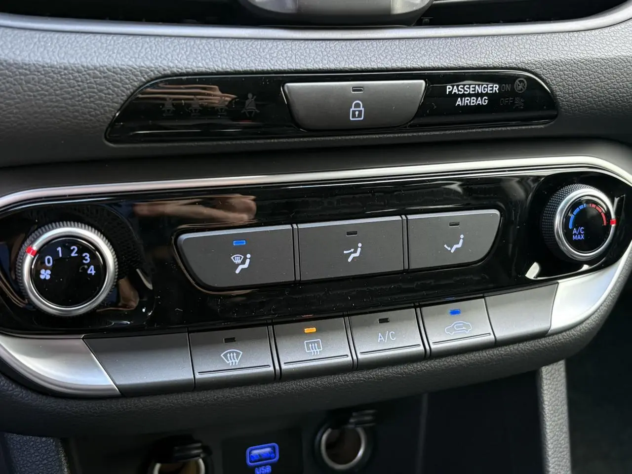 Gros plan sur la console centrale de la Hyundai i30 SW T-GDI 120 Modern 2025, boutons de climatisation et verrouillage.