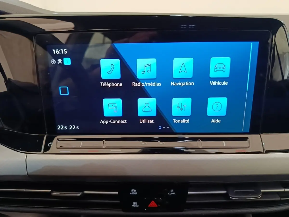 Écran tactile central bleu affichant les fonctions multimédias dans l’habitacle d’une Volkswagen Golf noire 2023.