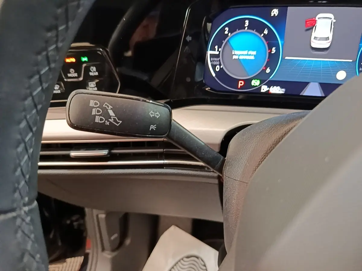 Gros plan intérieur sur le commodo gauche et tableau de bord numérique bleu de la Volkswagen Golf noire 2023.