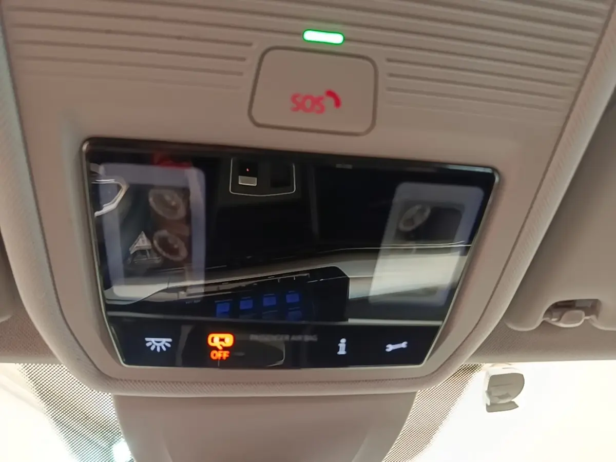 Vue en gros plan du panneau de commandes au plafond intérieur de la Volkswagen Golf noire 2023, avec bouton SOS et éclairage ambiant.