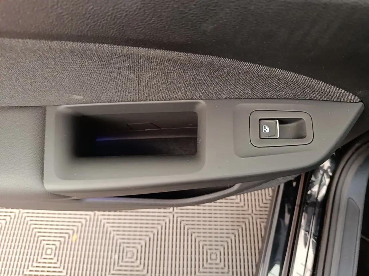 Détail de la poignée intérieure côté gauche de la porte noire d'une Volkswagen Golf 2.0 TDI 2023.
