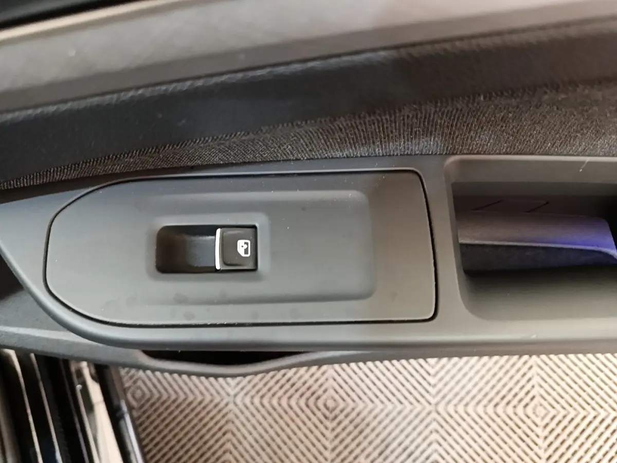 Gros plan sur le bouton de verrouillage centralisé dans la portière côté conducteur d'une Volkswagen Golf noire 2023.