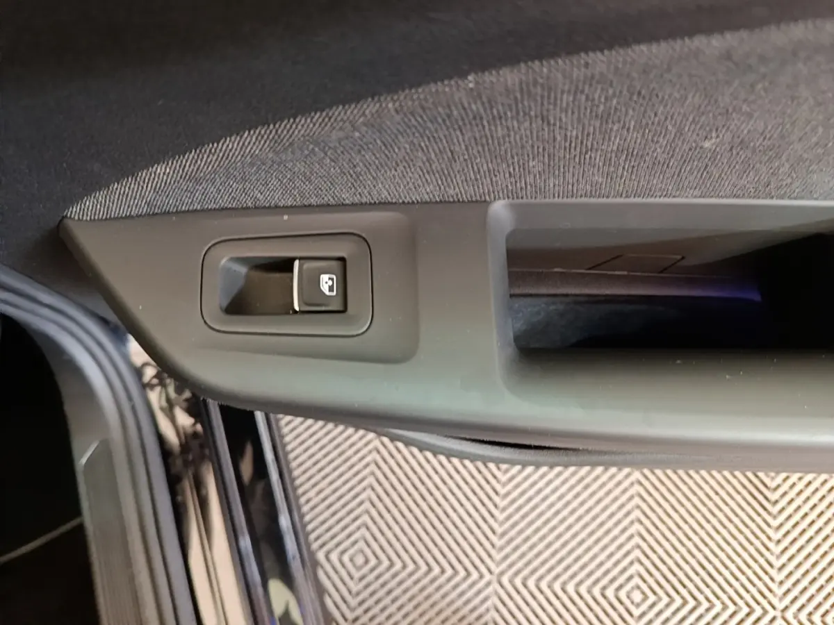 Détail de la commande de verrouillage de porte sur la portière avant gauche d’une Volkswagen Golf noire 2023.
