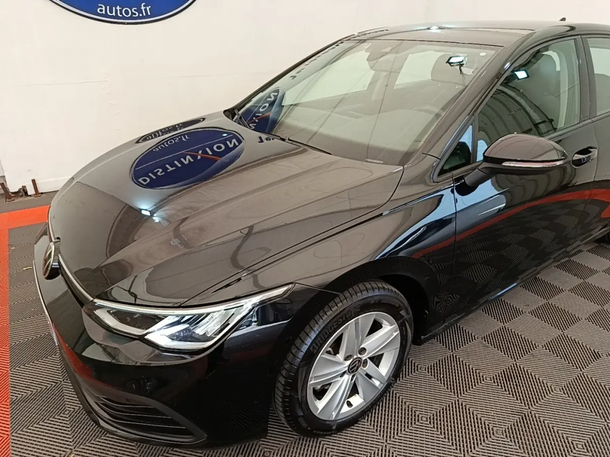 Volkswagen Golf noire vue 3/4 avant droit, avec phares LED et jantes alliage argentées visibles.