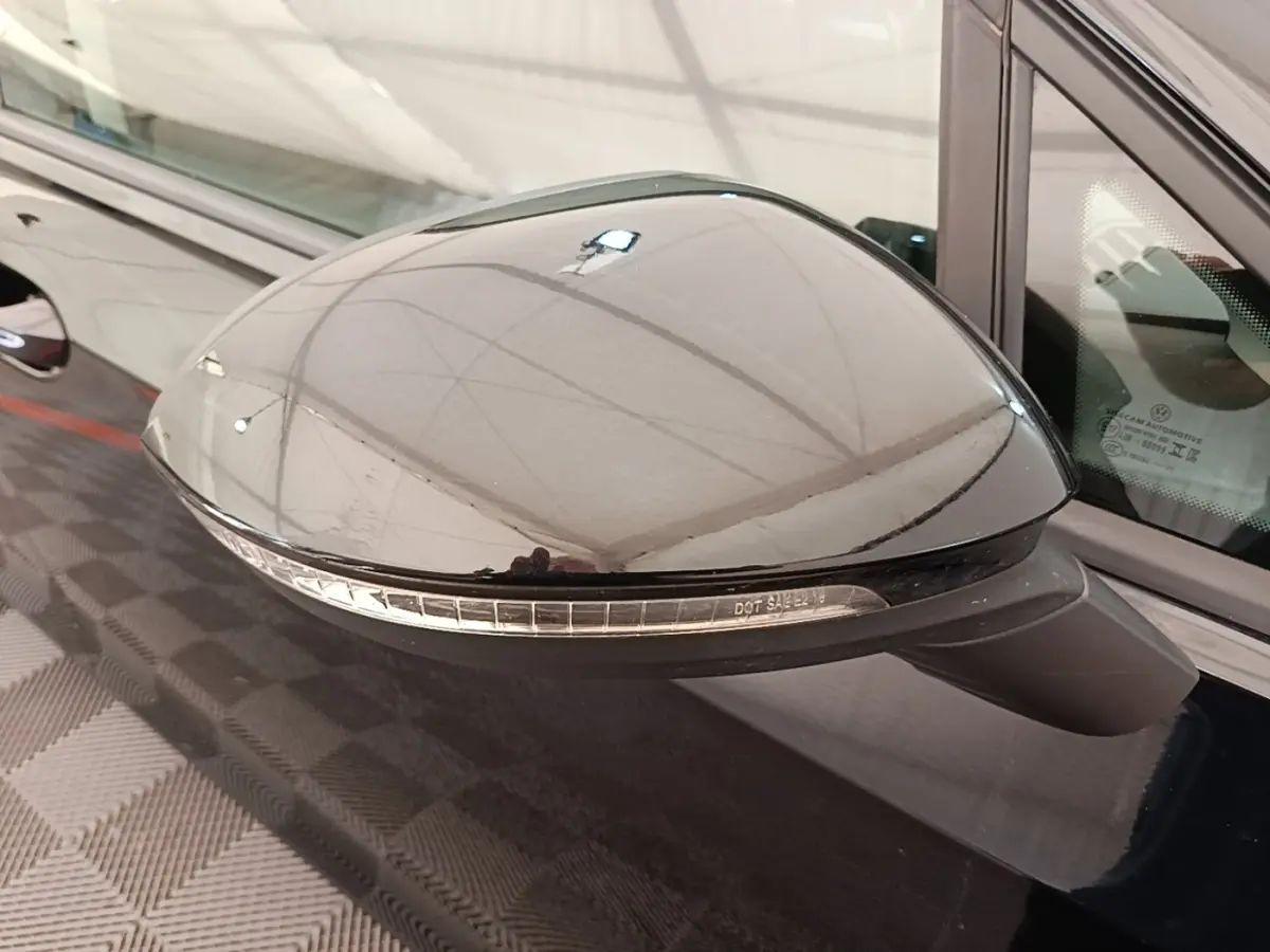 Rétroviseur côté gauche noir brillant avec clignotant intégré sur Volkswagen Golf 2023 vue rapprochée.
