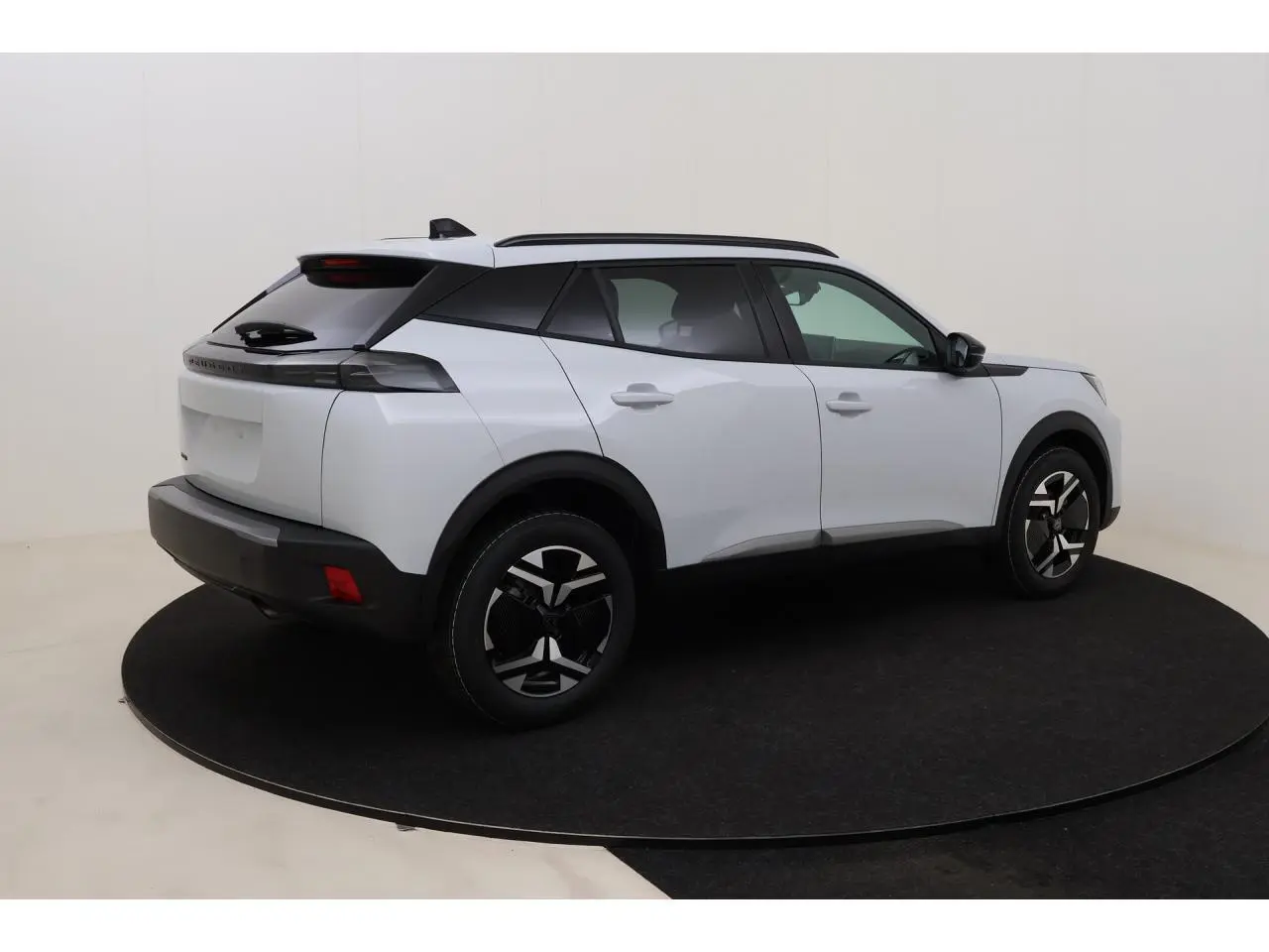 Peugeot 2008 blanc Okenite en vue 3/4 arrière droit, avec barres de toit noires et jantes distinctives.