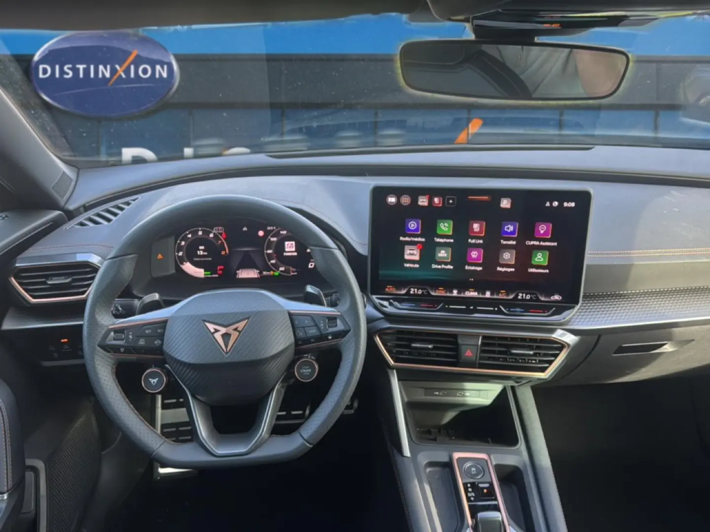 Vue intérieure frontale du tableau de bord et volant cuir du CUPRA Formentor 1.5 ETSI Hybrid avec écran tactile et finitions orange.