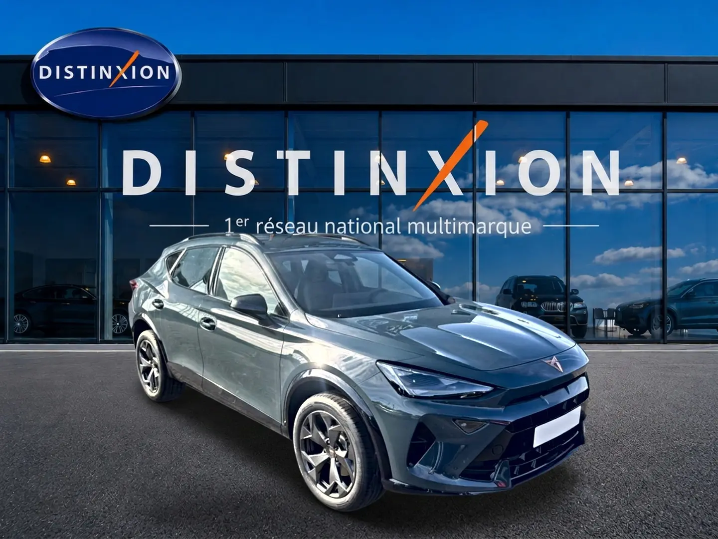 Vue 3/4 avant d'un CUPRA Formentor bleu fjord 2026 avec jantes 18 pouces, devant une vitrine Distinxion.