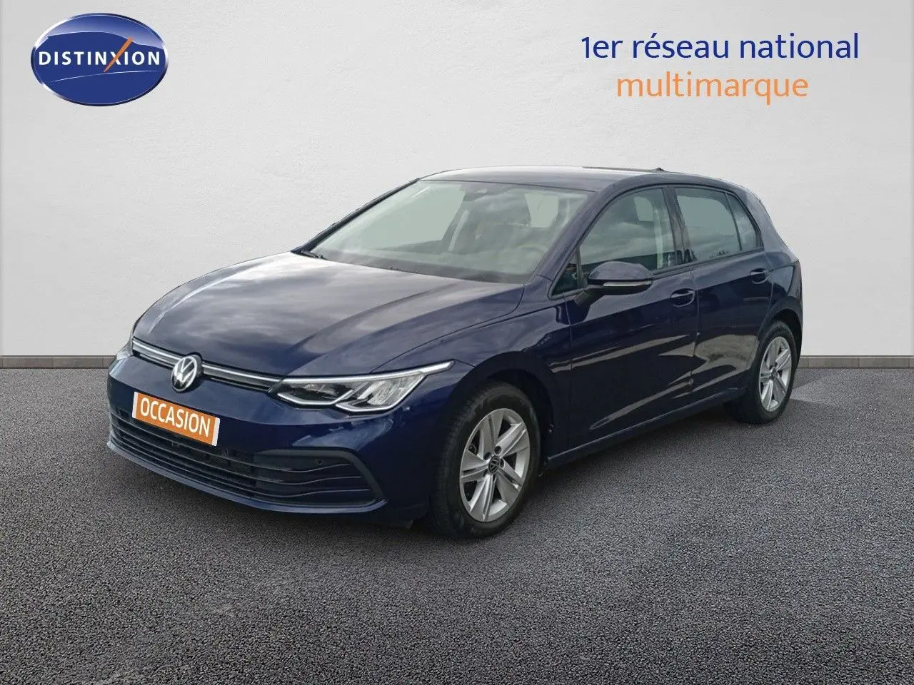 Volkswagen Golf VIII bleu Atlantique métal vue 3/4 avant droit sur sol gris devant un mur blanc.