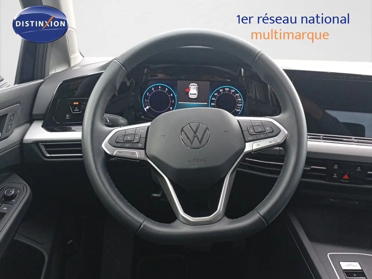 Vue intérieure centrée sur le volant multifonction noir de la Volkswagen Golf VIII 2023 avec tableau de bord digital.