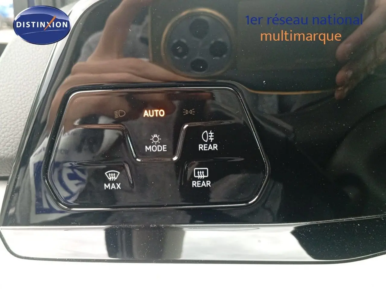 Gros plan sur les commandes d'éclairage et de dégivrage arrière d'une Volkswagen Golf VIII bleu Atlantique métal.