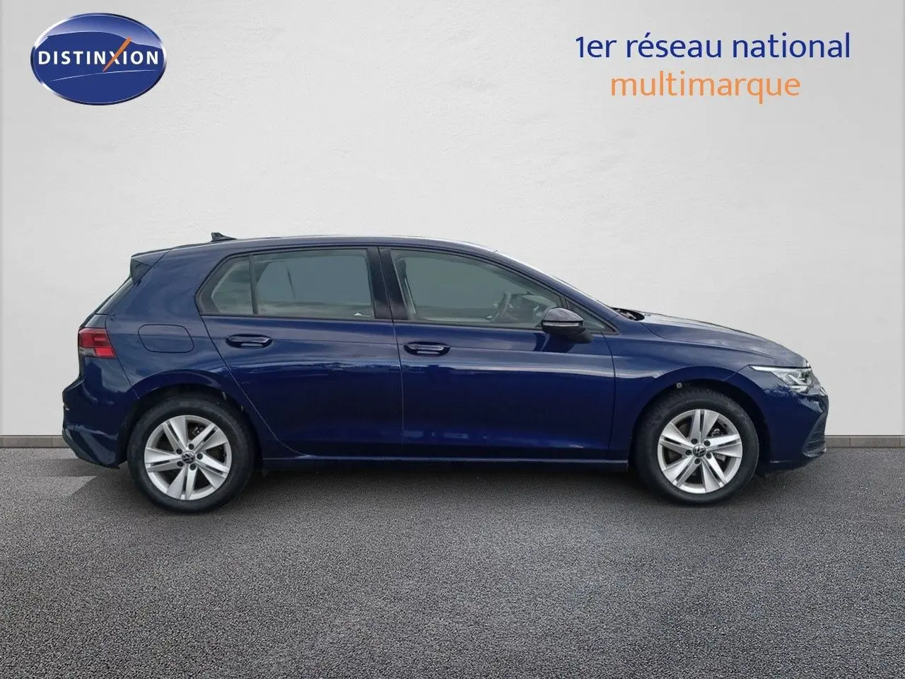 Profil côté gauche d'une Volkswagen Golf VIII bleu Atlantique métallisé avec jantes alliage et cinq portes visibles.