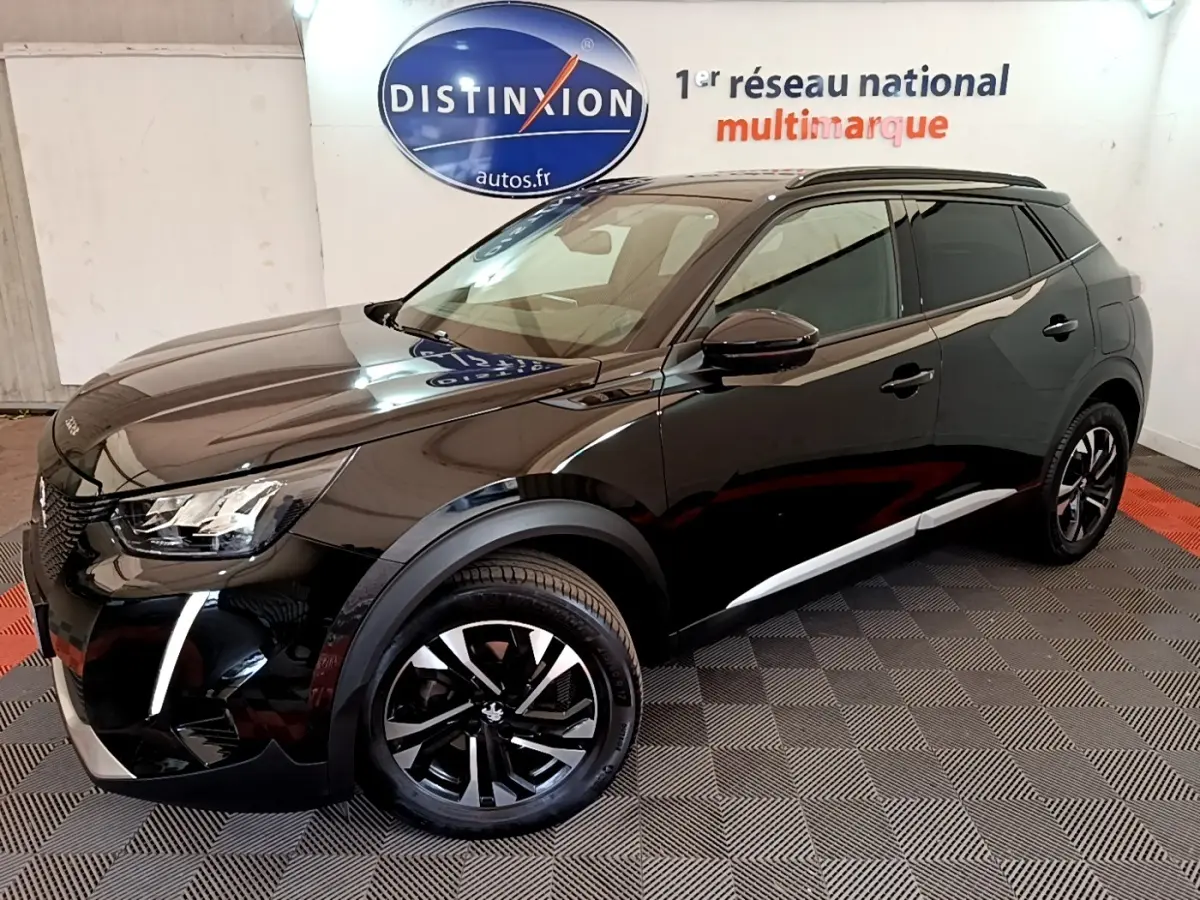 Peugeot 2008 noir vue 3/4 avant droit en intérieur, avec jantes alliage et feux LED distinctifs.