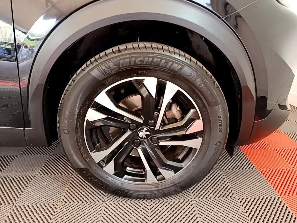 Gros plan sur la roue arrière droite noire avec jante alliage bicolore du Peugeot 2008 BlueHDi 130 de 2021.