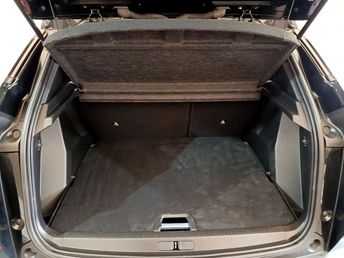 Coffre ouvert vu de l'arrière d'un Peugeot 2008 noir, montrant l'espace de chargement et la tablette de séparation.
