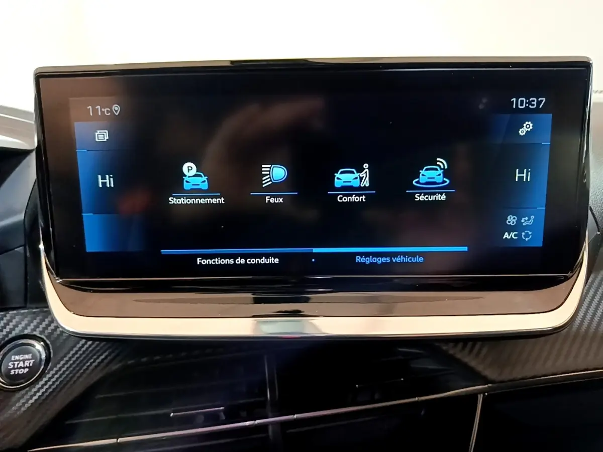 Écran tactile central du tableau de bord de la Peugeot 2008 noir, affichant les réglages de conduite et sécurité.