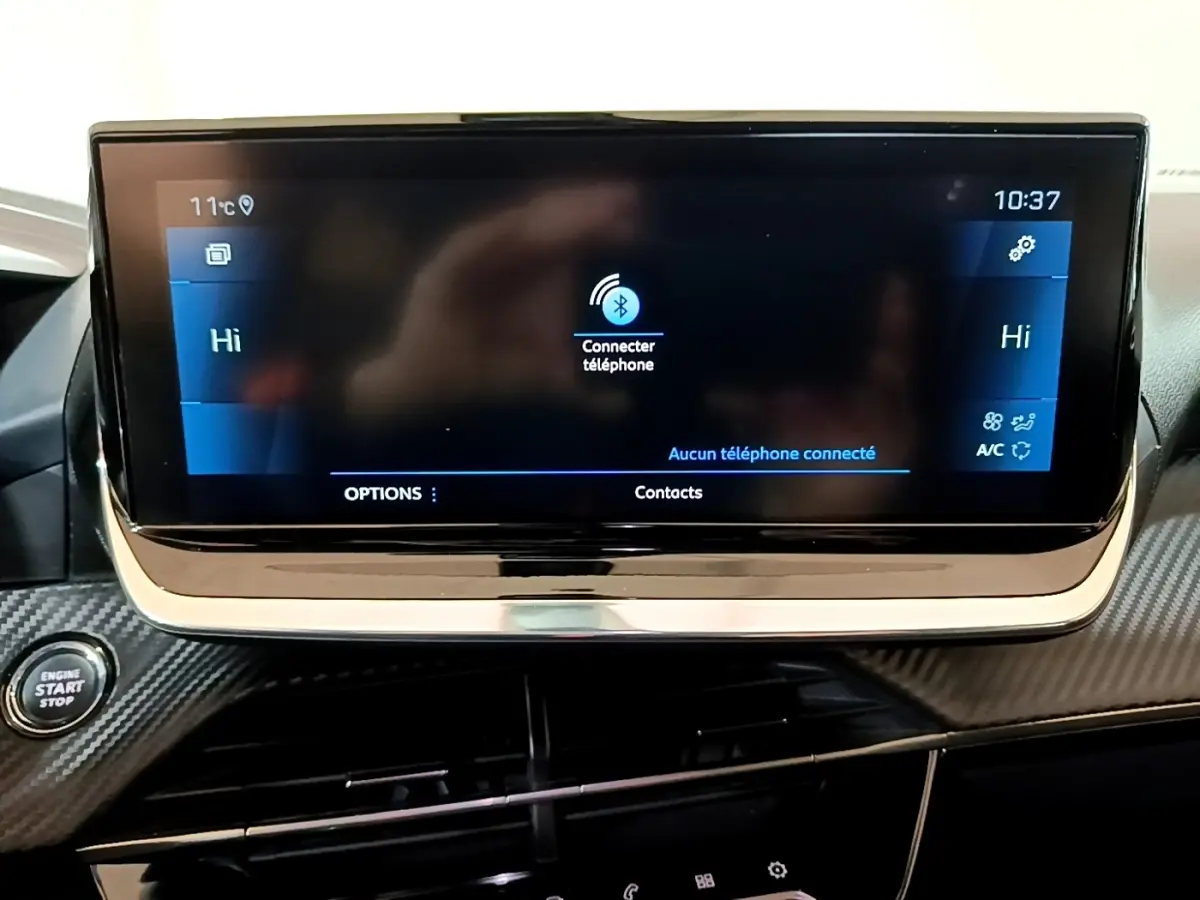Écran tactile central affichant la connexion Bluetooth dans l’habitacle noir du Peugeot 2008 vue de face.