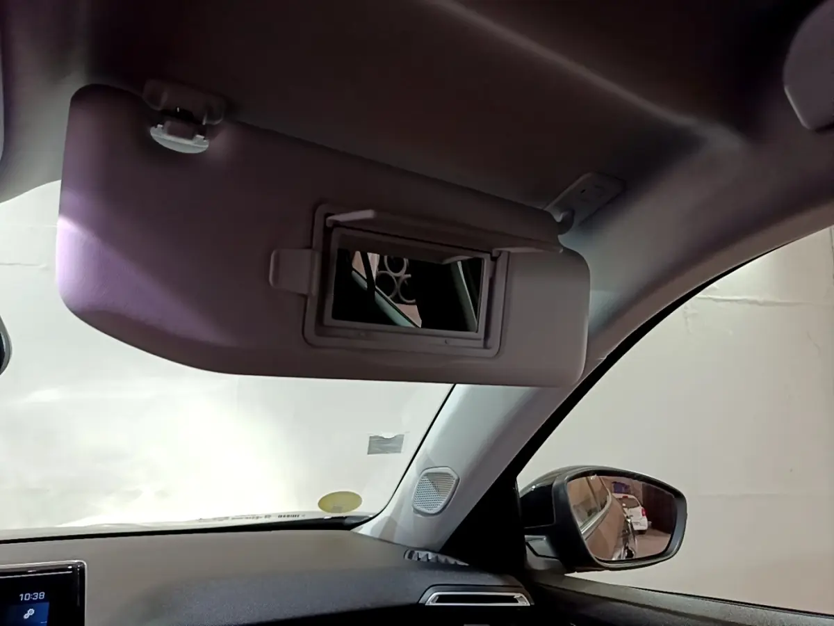 Intérieur du Peugeot 2008 noir, vue sur pare-soleil côté conducteur avec miroir ouvert et rétroviseur extérieur droit.